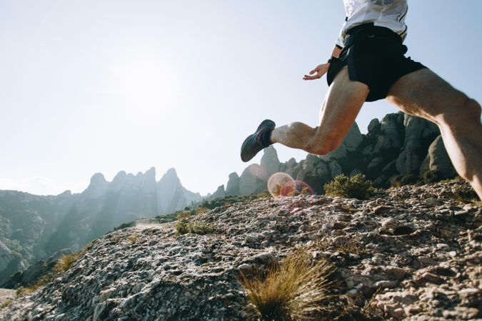 Legs of man trail running on a sunny day