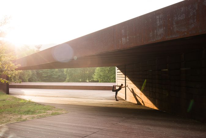 young woman stretching leaning in a amazing geometrical building