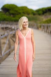 Vertical composition of mature female with grey hair going for a stroll on wooden walkway