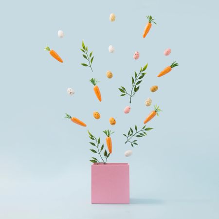 Spring leaves, Easter eggs and carrots coming out of pink box