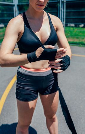 Sportswoman putting on boxing bandages