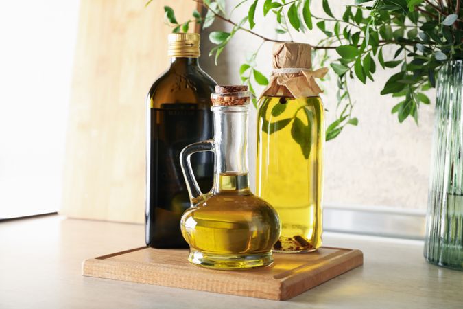 Bottles with oil and plant on kitchen table