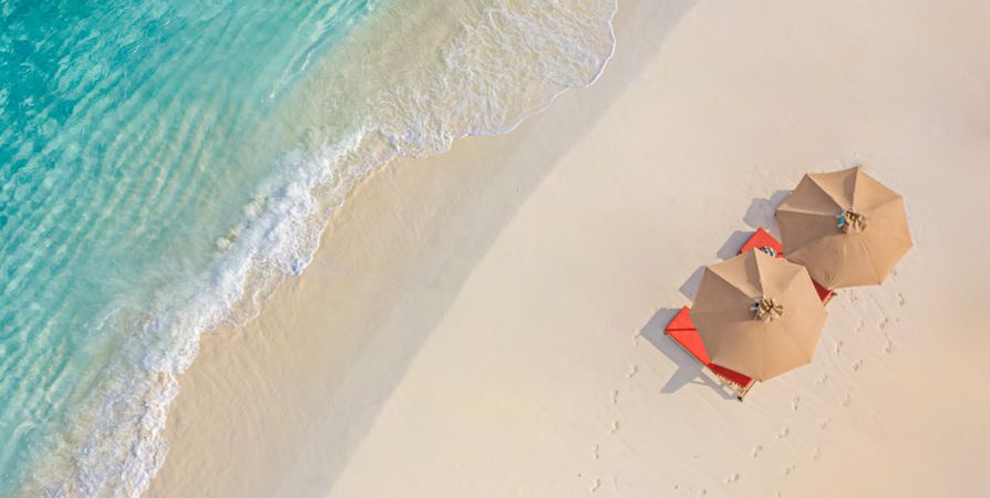 Two parasols and reclining chairs on a tropical beach