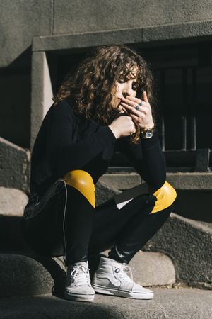 Young woman smoking cigarette in the street