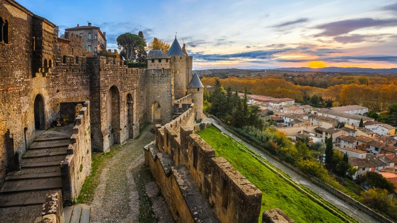 Aude door at fortification castle in Carcassonne. A castle with a view of a town and a green hill