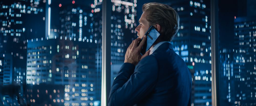 Backview of White Businessman in Stylish Suit Standing Next to Window
