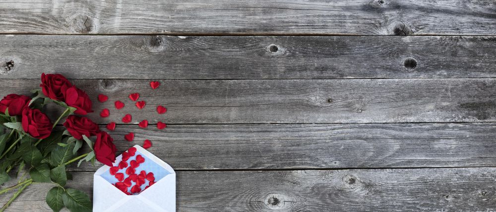 Valentine’s day with love letter and roses on wood