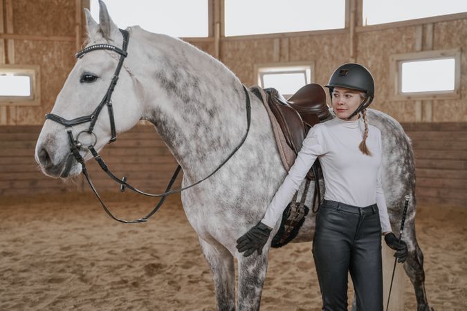 Rider with dapple gray horse in round arena