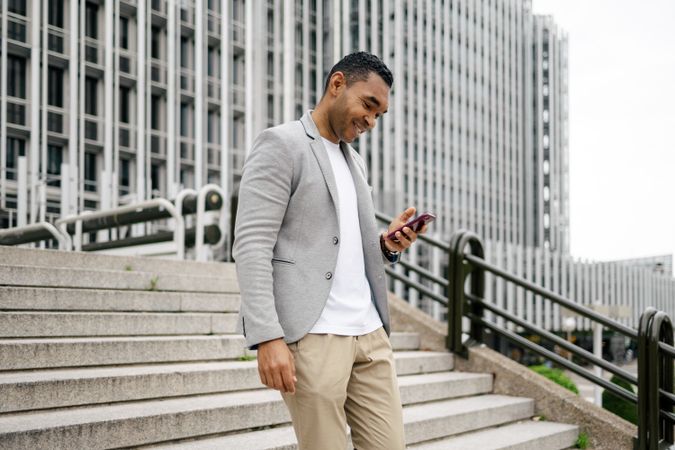 Man walking in financial area with smartphone