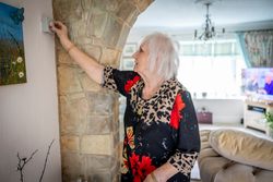 Woman adjusting thermostat