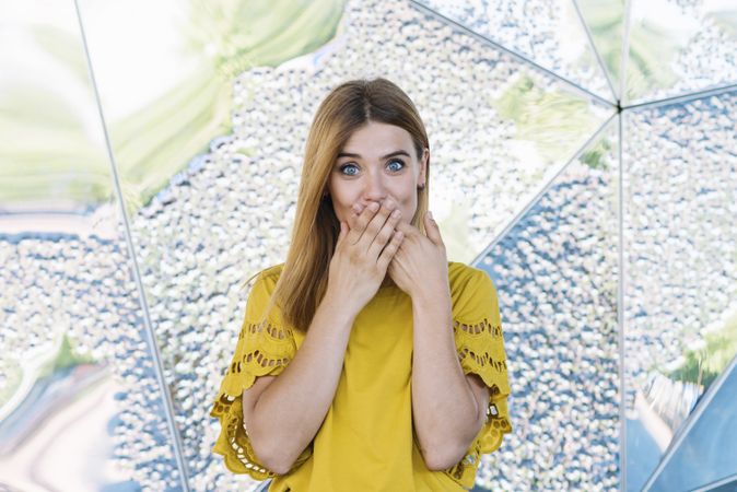 Young shy woman covering mouth