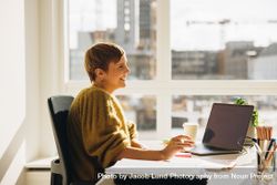 Woman looking away and smiling while working in office 4jVr69