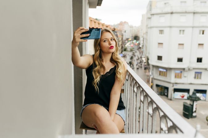 Young smiling female taking selfie on terrace