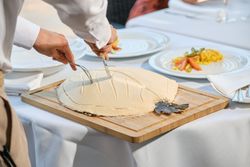 Crop waiter serving fish baked in salt crust