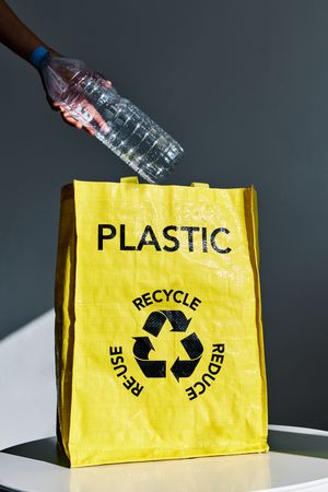 Woman putting plastic bottle in bag