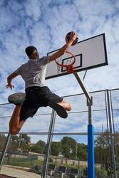 Faceless basketball player jumping on sports ground