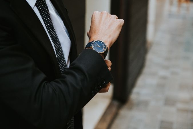 Young stylish man in costume with watch
