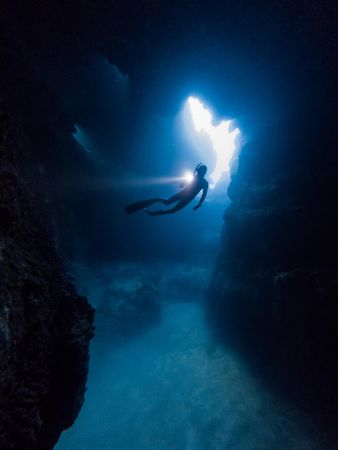 Person diving underwater cave