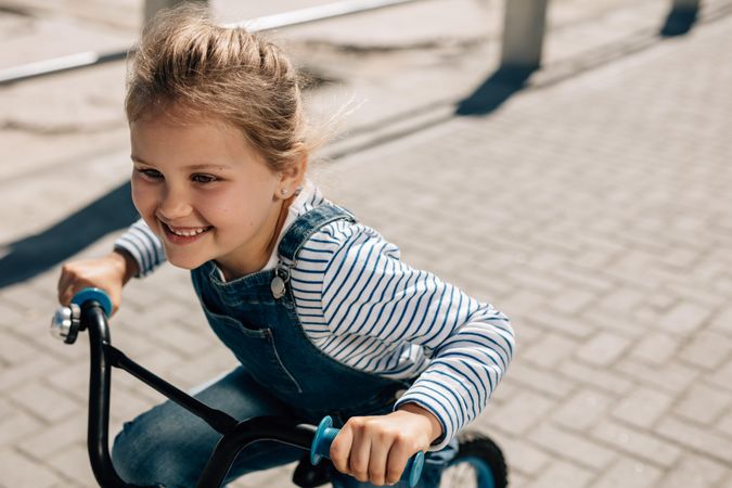 Young girl riding her bicycle on road
