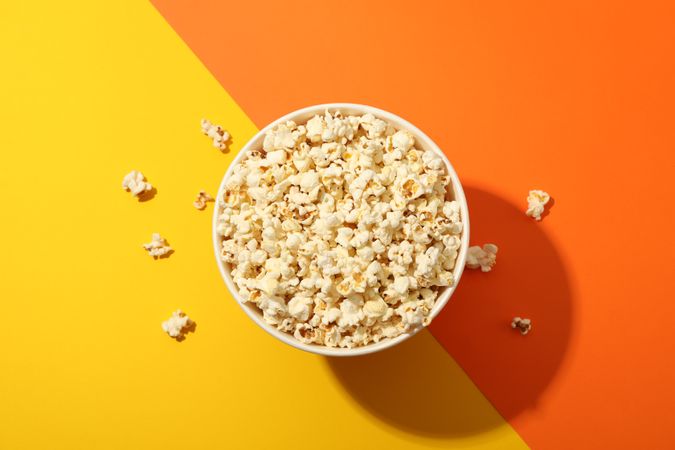Flat lay composition. Bucket with popcorn on two tone background
