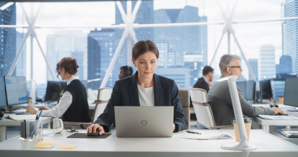 Successful White Woman Working With Annual Report In Multiethnic Workspace.