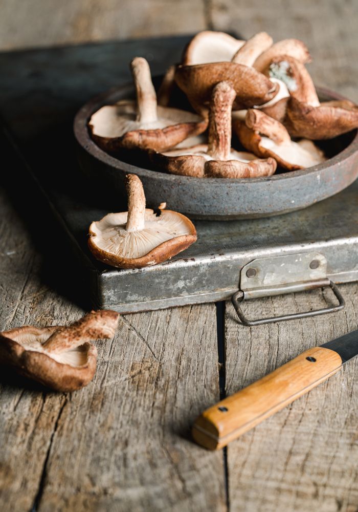 Pile of fresh brown mushrooms on rustic wooden table