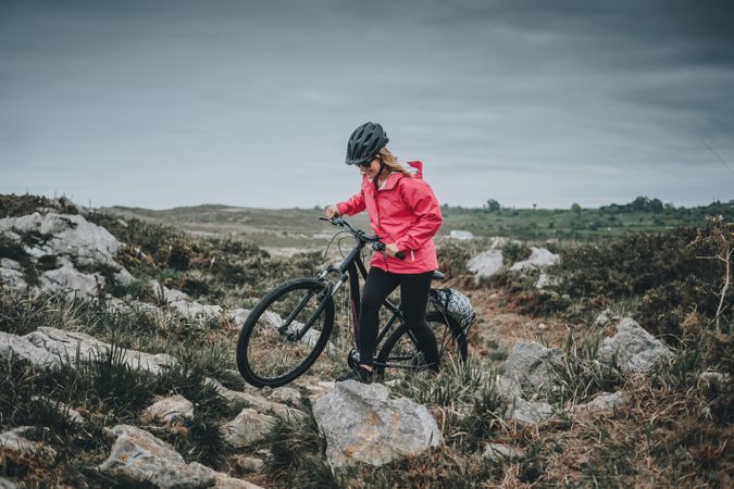 Anonymous female bicyclist on rocks