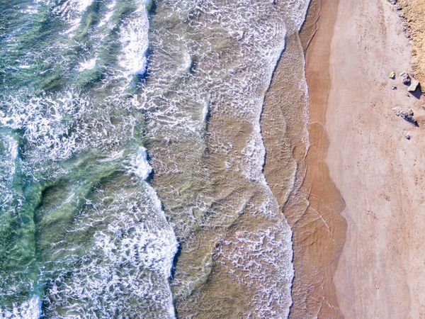 Looking down at beautiful beach with waves coming into sandy beach
