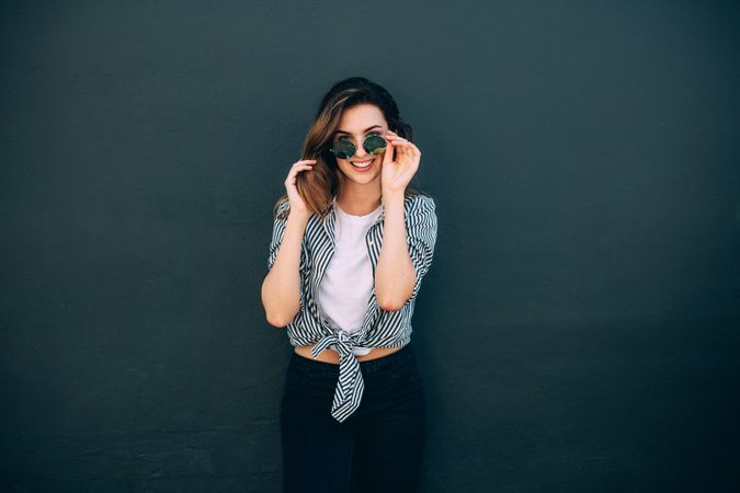 Happy looking woman standing against a wall posing for photograph