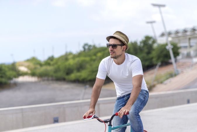 Male in hat having a relaxing bicycle ride outside