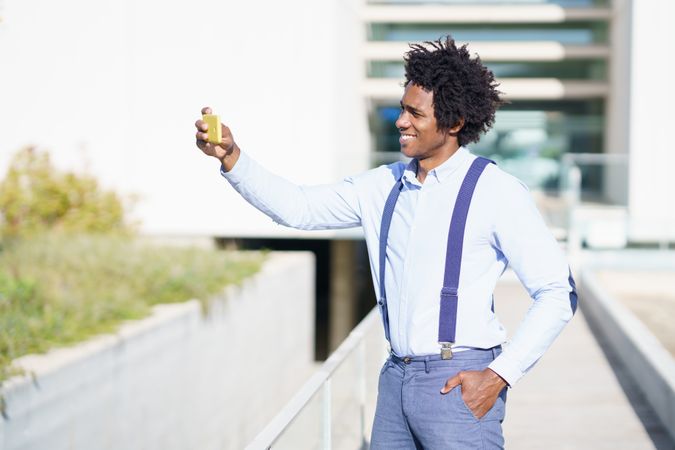 Man taking a selfie with his phone on a sunny day