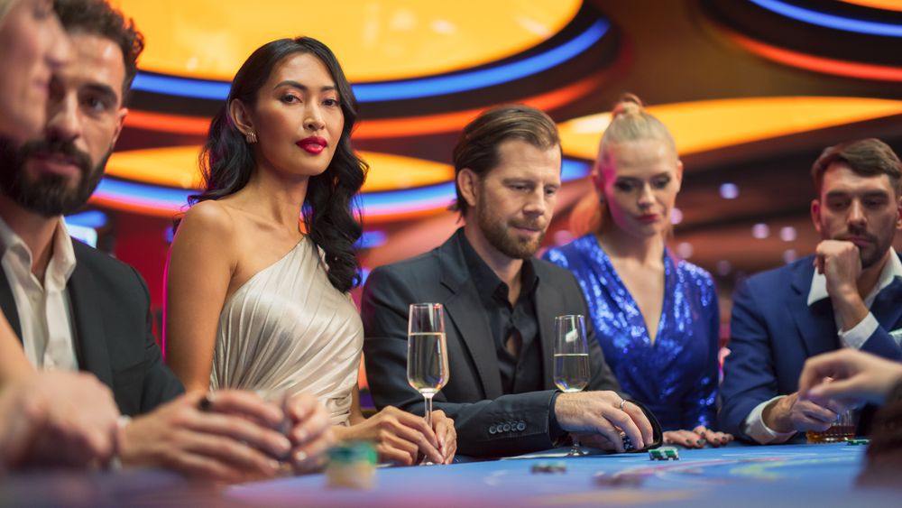 Portrait of a Glamorous Asian Woman Sitting at a Blackjack Table with Friends in a Modern Casino.