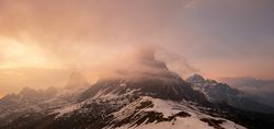 Mountain peak in foggy haze at sunset