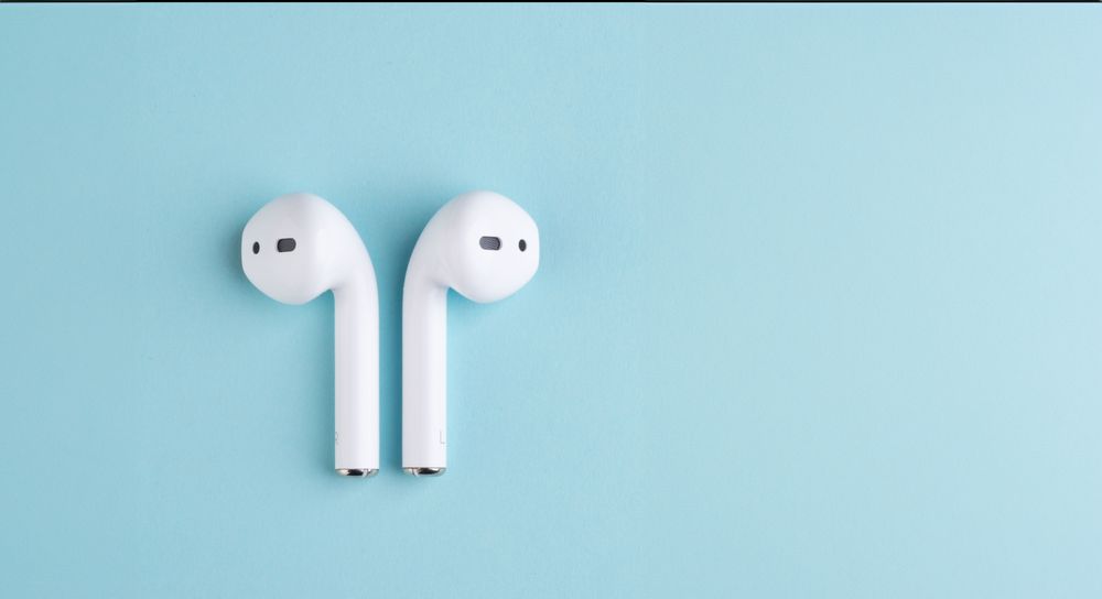 Minimalist earbuds on turquoise background