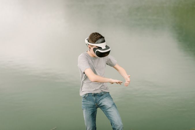 Young teenager with virtual reality glasses outdoors