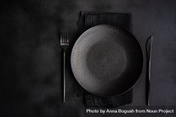 Table setting with dark plate, napkin and silverware 5pgOYO