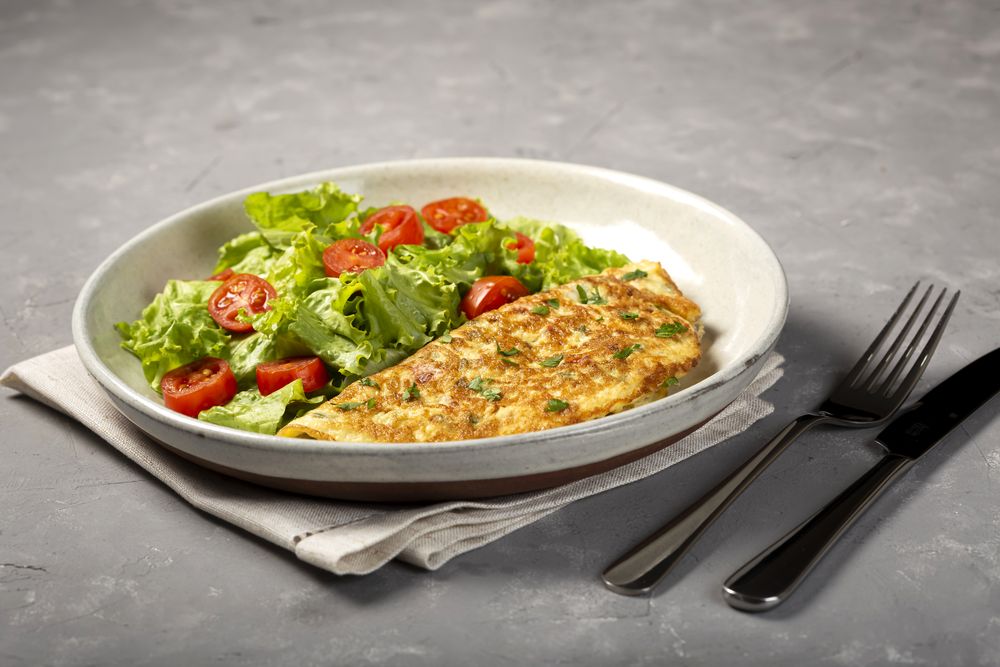 Omelet with cheese and lettuce and tomato salad.