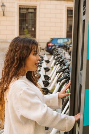 Young woman on bike sharing station