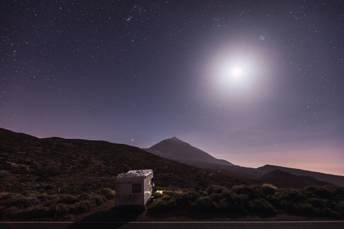 Traveling caravan in desert with bright moon