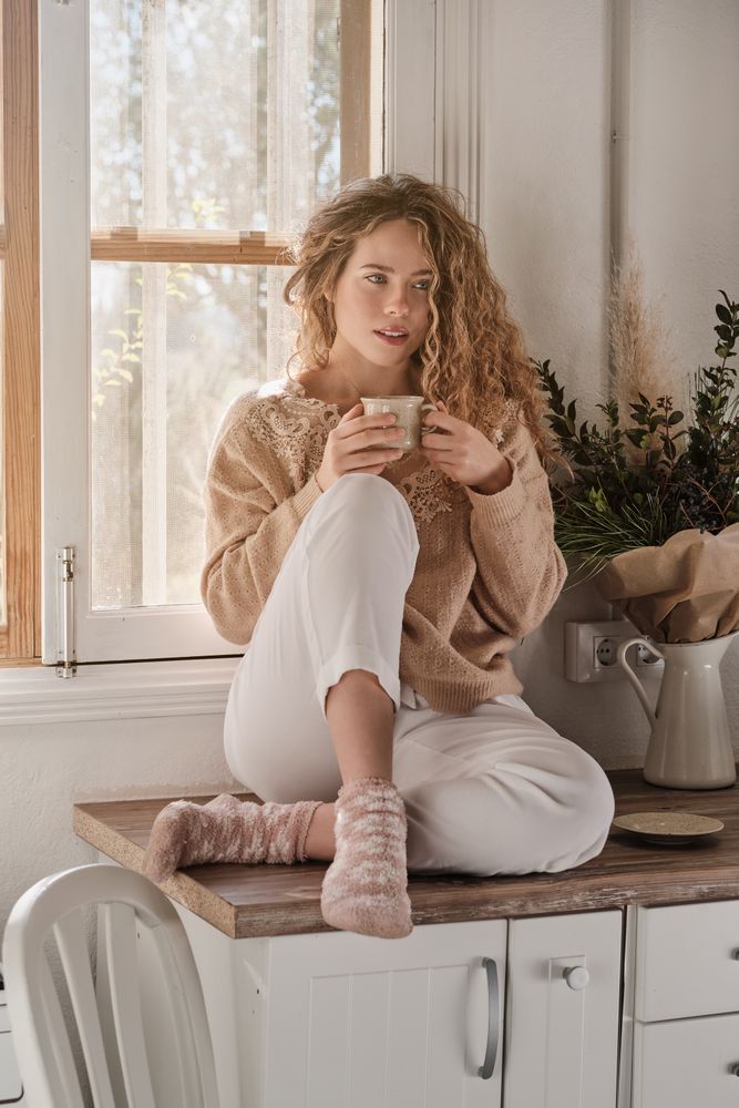 Young woman drinking hot coffee at home