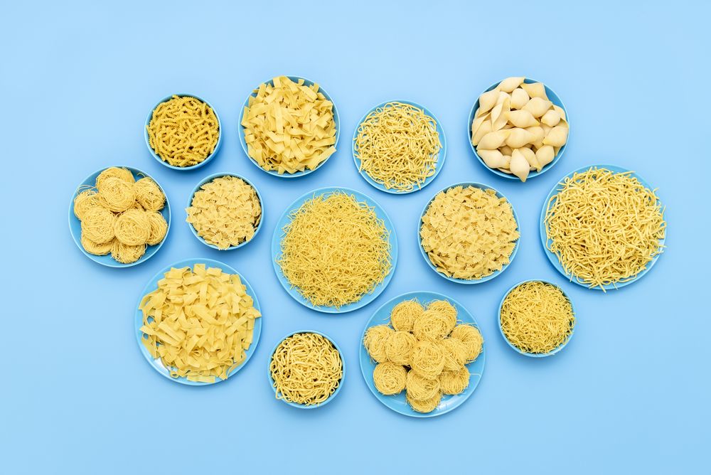 Pasta variety in blue plates above view on a blue table