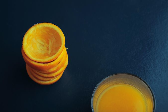 Stack of squeezed tangerines and a glass of juice, landscape