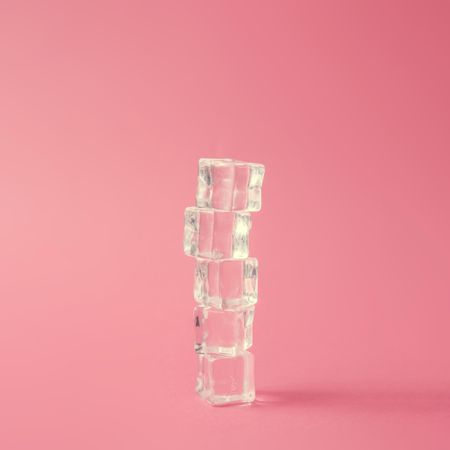 Stacked ice cubes against pink background