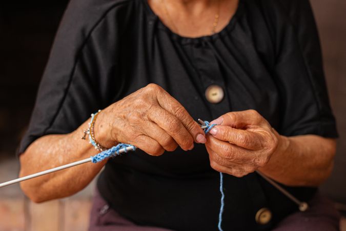 Weaving tales. Mature hands knit life's journey.