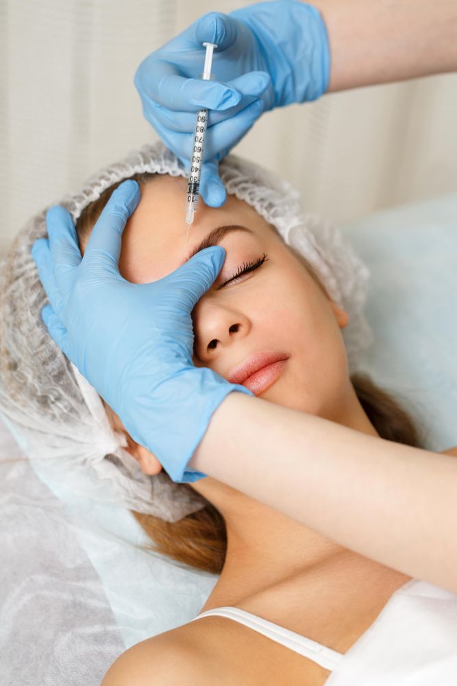 Cosmetologist at med spa injecting face of female client