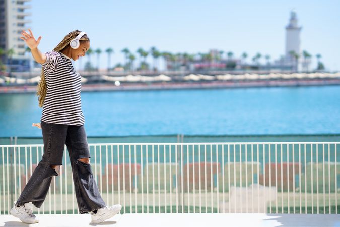 Play fun female on one leg near on walkway beautiful blue water, copy space