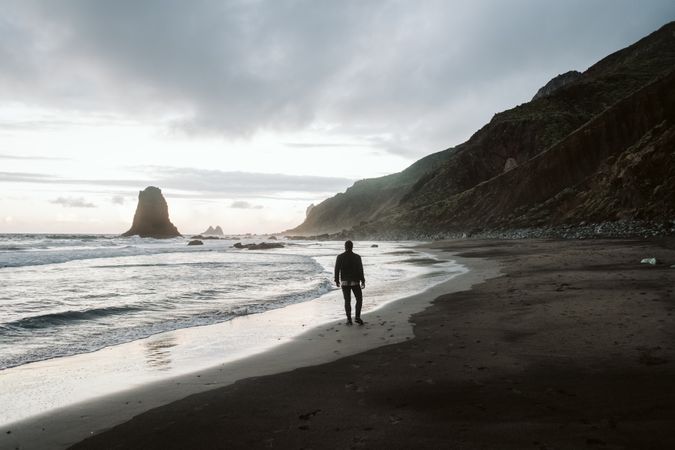 Anonymous man standing near sea