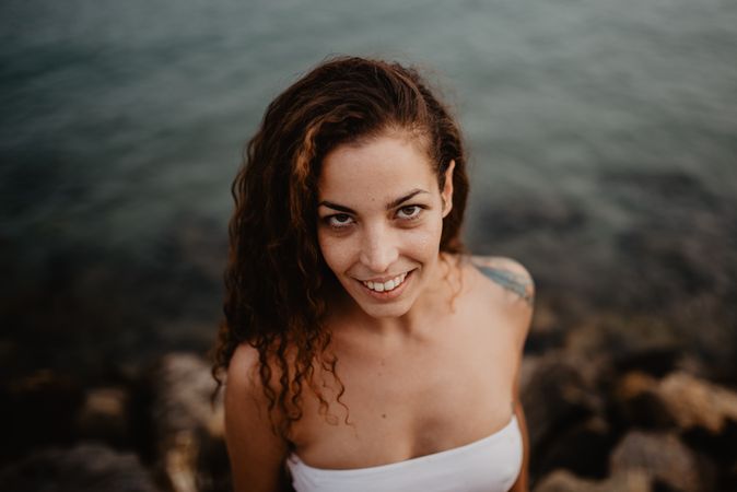 Smiling woman standing near sea