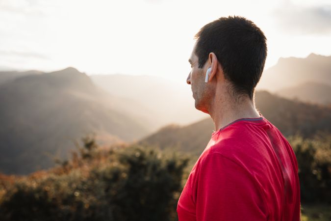 Male runner resting and enjoying mountain landscape