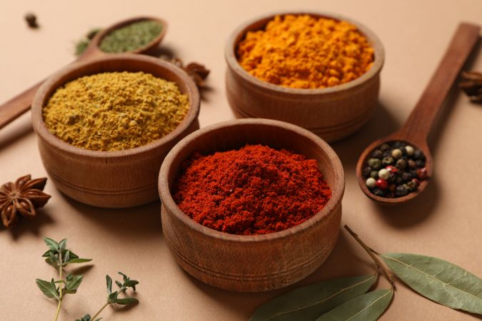 Bowls of cumin and turmeric with wooden spoons